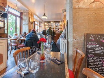 La salle du Valmy vue d’une table, le bar au fond